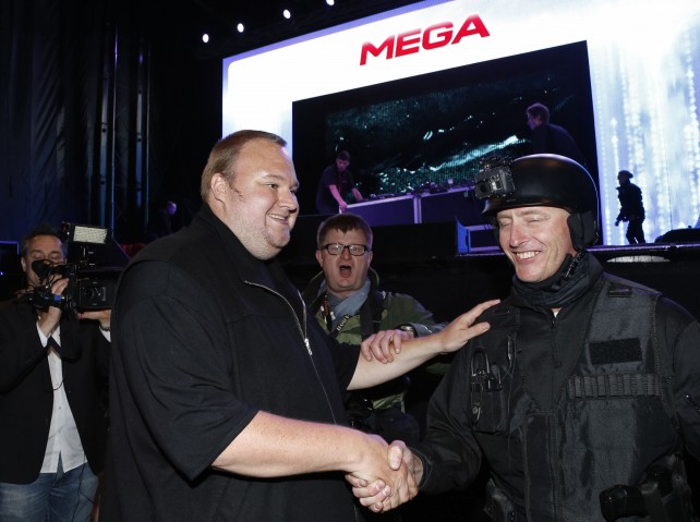 An actor in police costume greets Kim Dotcom as he launches his new website "Mega" in Auckland